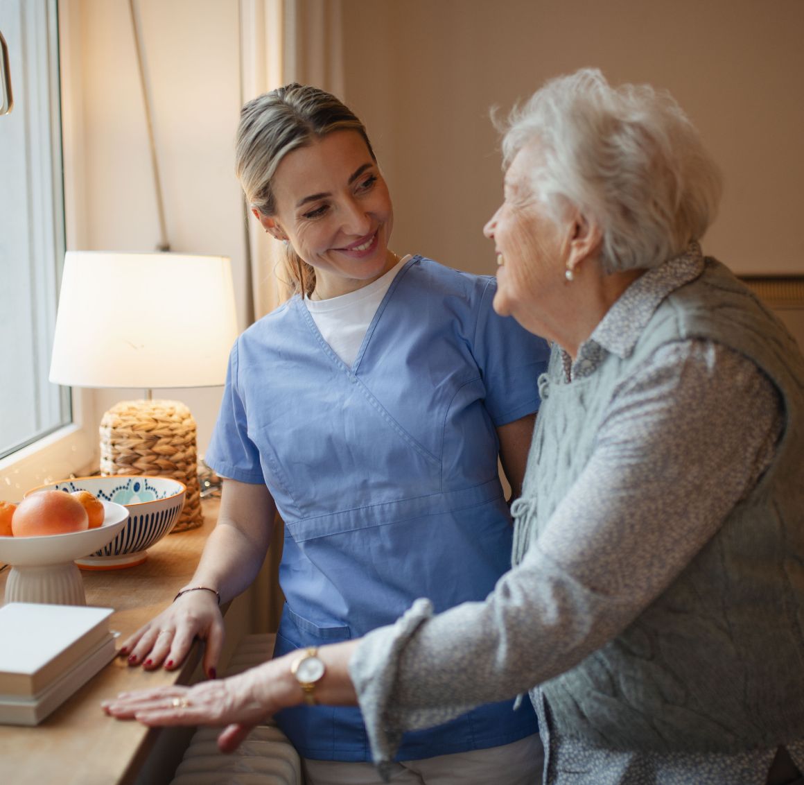 Caregiver standing with an elderly smiling lady