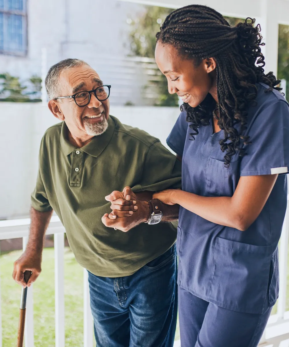 Caregiver helping senior man walk with cane